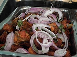 Chicken 65 with onion and coriander garnish