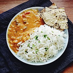 Dal tadka served with rice and papadam, a staple meal in the Indian subcontinent