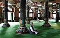 The mosque's interior has intricate woodwork and is richly decorated with papier-maché, seen above in 2007; the wooden structure makes it prone to fires, the latest such incident occurring in 2017