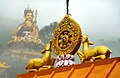 Dharmachakra in front of a statue of Padmasambhava. Lake Rewalsar, Himachal Pradesh