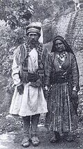 A man dressed in achkan with dora or sash wrapped around the waist.