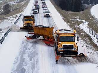 Trucks plowing snow on a highway in Missouri