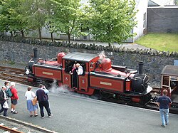 Red locomotive, with observers on a platform