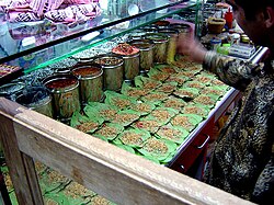 Shopkeeper making paan in an Indian store.