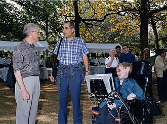 Hawking outside, in his wheelchair, talking to David Gross and Edward Witten