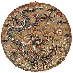 Roundel with dragon design. China, Qing-dynasty, late 17th century. Peacock feather barbules are used to highlight the dragon's scales.