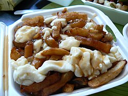Poutine, a Canadian dish of fried potatoes, cheese curds, and gravy