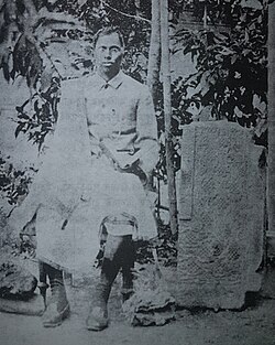 Achyut Charan Choudhury seated next a stone fragment from the Pratapgarh Kingdom, c.1900s