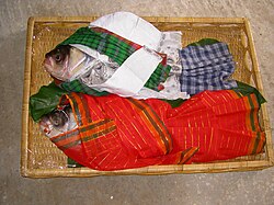 The groom's family members often bring fish decorated as a wedding couple to the bride's gaye holud