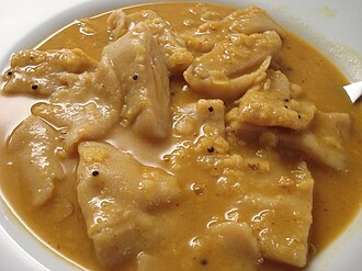 Yellow coloured dal with thick wheat flour dhoklis in it.
