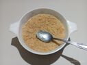 A bowl filled with pheni soaked up in milk, along with a spoon
