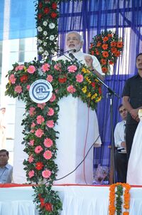 Modi speaking at flower-decked podium