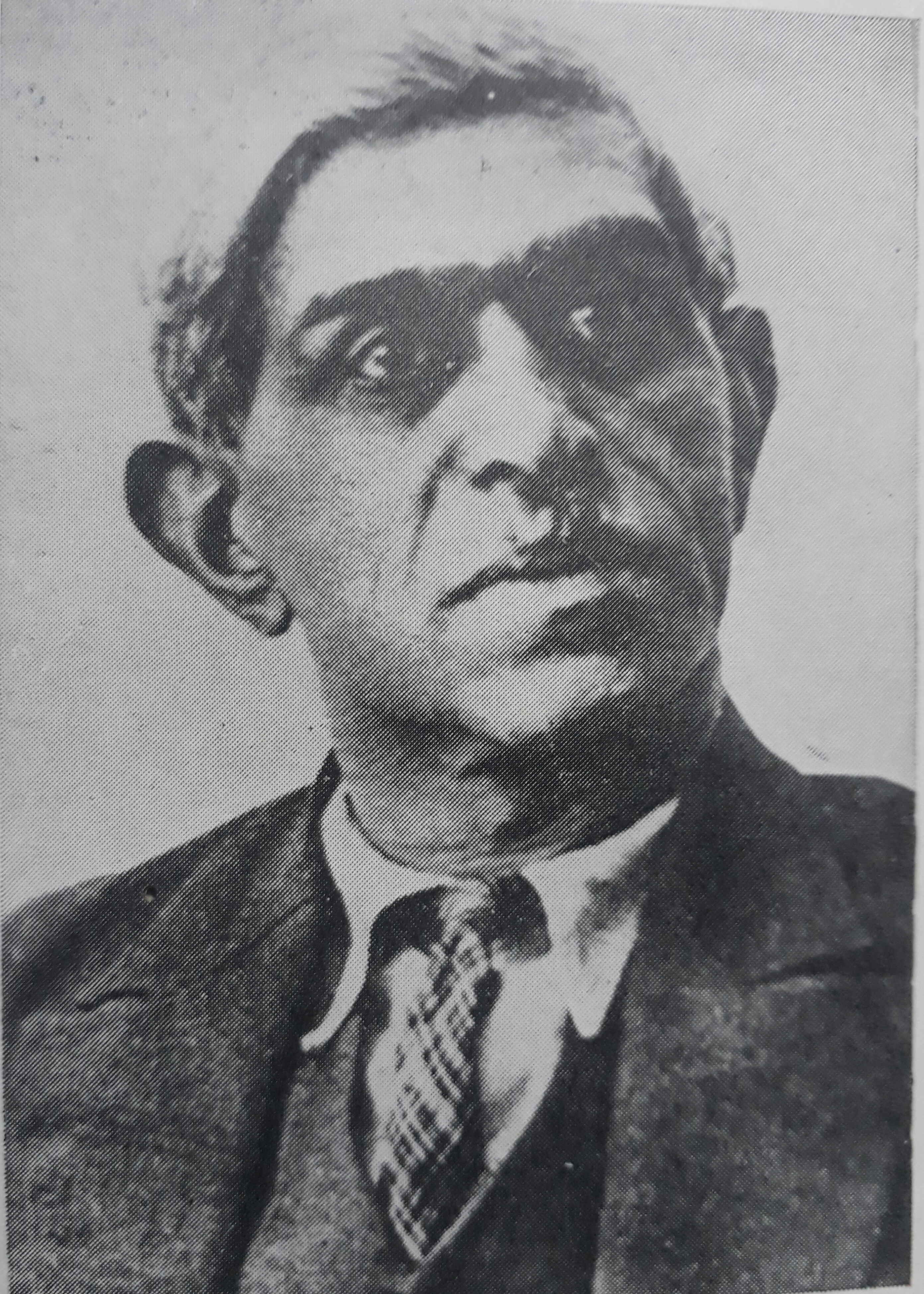 Black and white portrait photograph of a man wearing a suit