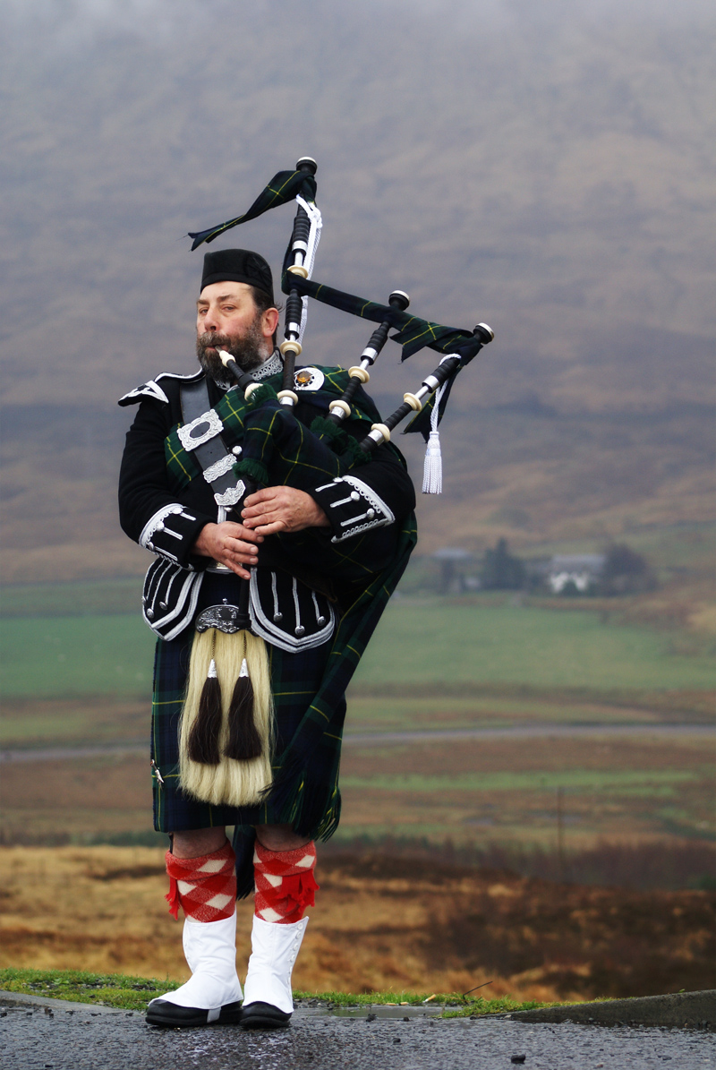 Man playing bagpipes in the Highlands