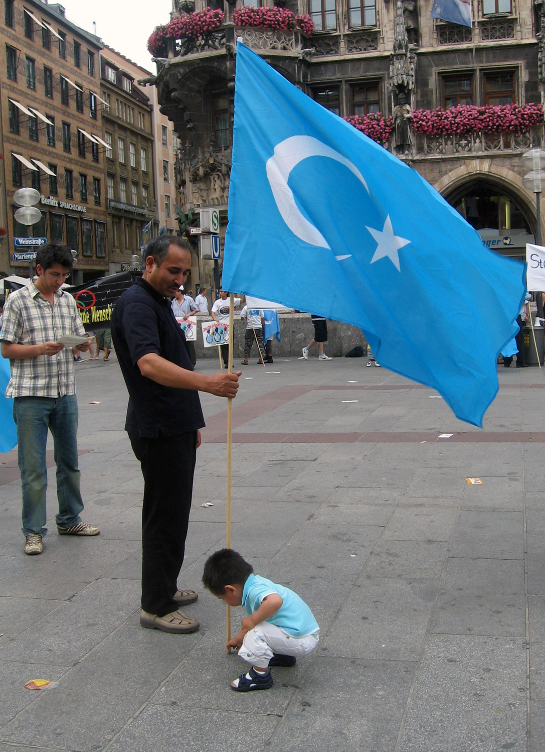 Uyghur man with Kökbayraq flag in Munich, Germany